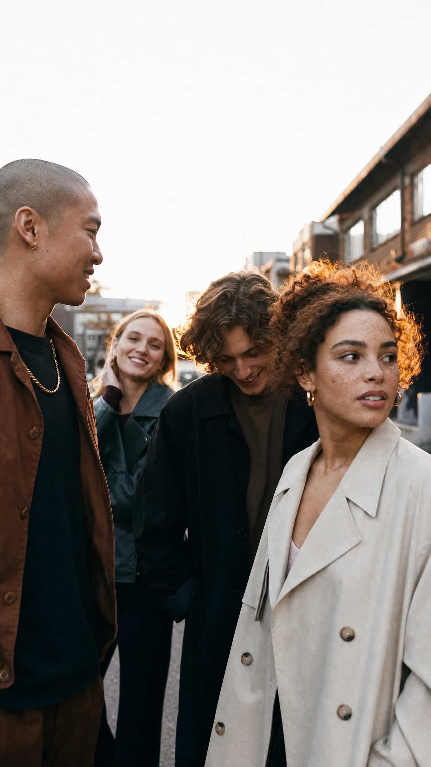 Groupe d'amis souriants réunis dans une rue au coucher du soleil